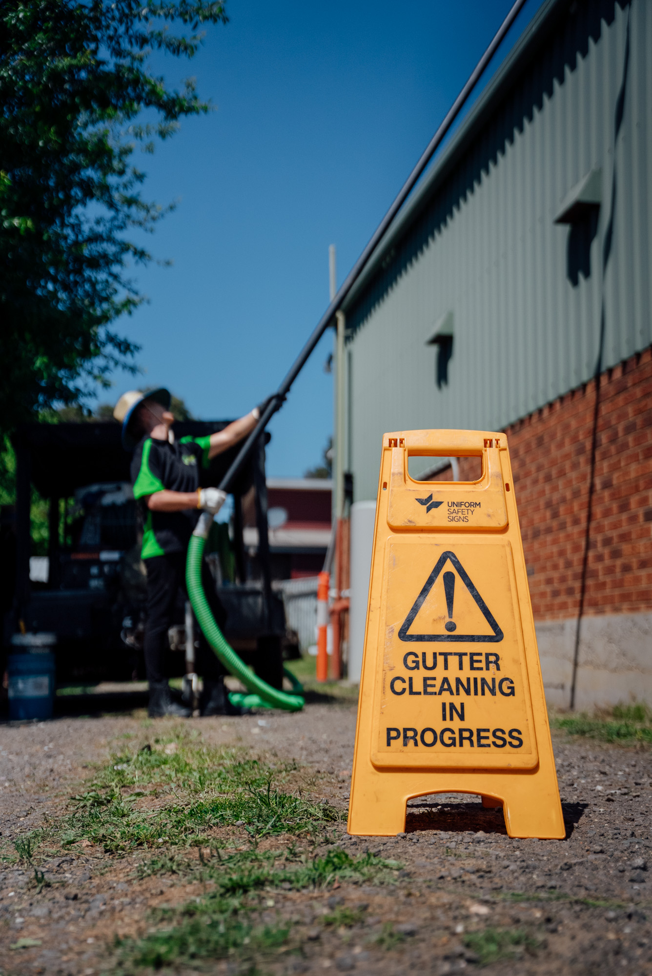 Green Clean Team technician cleaning gutters from the ground in Central Victoria