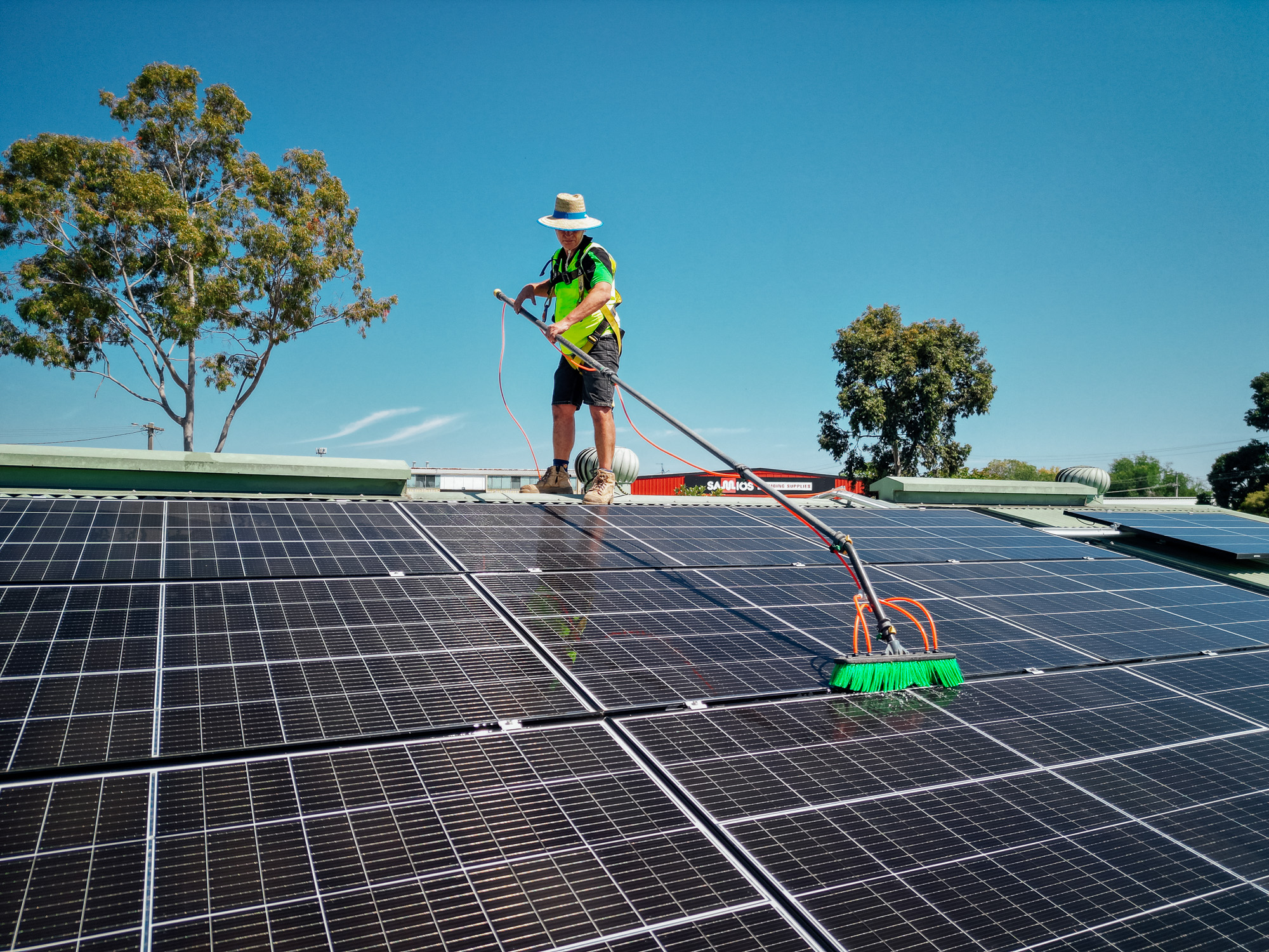 Green Clean Team technician using water-fed pole to clean rooftop solar panels in Central Victoria